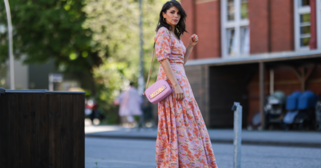 Mandy Bork vista usando óculos escuros marrons da Tom Ford, um vestido longo colorido com botões / plissados ​​/ sem mangas da Emilio Pucci, uma mini bolsa Hermes Kelly rosa claro e sandálias creme brancas da Chanel, durante a Paris Fashion Week - Haute Couture Outono Inverno 2022 2023, em 06 de julho de 2022 em Paris, França.