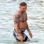 Tom Hardy exibiu sua variedade de tintas corporais enquanto relaxava na praia com sua esposa Charlotte Riley em férias em família em Barbados na quarta-feira.