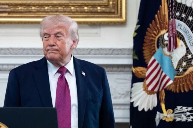 Donald Trump em um pódio em frente ao Selo Presidencial.