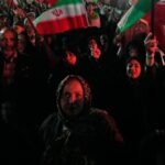 Manifestantes pró-governo agitam bandeiras iranianas em Teerã na segunda-feira.