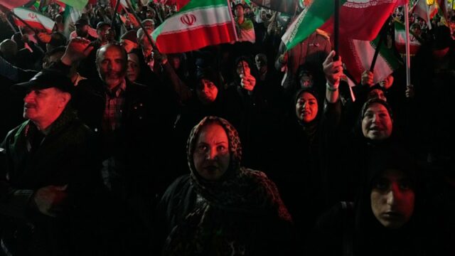 Manifestantes pró-governo agitam bandeiras iranianas em Teerã na segunda-feira.