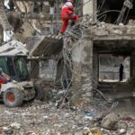 Trabalhadores e civis revistam os escombros de edifícios residenciais destruídos nos ataques dos EUA e de Israel em Teerã.