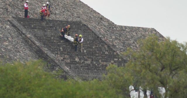 Trabalhadores forenses carregam o corpo de uma vítima para baixo de uma pirâmide depois que as autoridades disseram que um homem armado abriu fogo, em Teotihuacan, México, segunda-feira, 20 de abril de 2026.