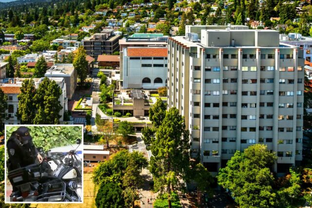 Um policial uniformizado parado ao lado de uma motocicleta e um carro da polícia no campus da UC Berkeley.