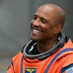 Os quatro astronautas da missão Artemis II em seus trajes espaciais laranja ficam lado a lado do lado de fora do Edifício de Operações e Checkout do Centro Espacial Kennedy