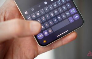 Um futuro que prioriza a voz parece exaustivo, então não pare de digitar Uma mulher sentada usando o assistente de voz em seu telefone, com um robô de IA ao lado dela.