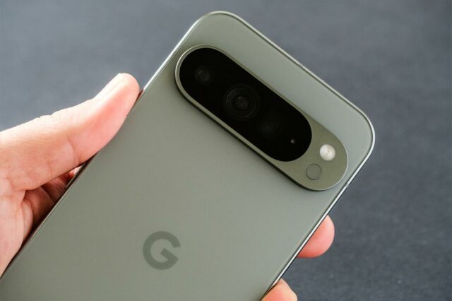 Close do Google Pixel 9 Pro XL em Hazel Green, com foco na câmera tripla, segurada na mão.