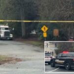 Um caminhão de reboque em uma estrada bloqueada por fita amarela.