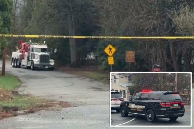 Um caminhão de reboque em uma estrada bloqueada por fita amarela.