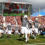 Vídeos mostram paraquedista batendo no placar do estádio enquanto a multidão assiste