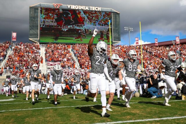 Vídeos mostram paraquedista batendo no placar do estádio enquanto a multidão assiste
