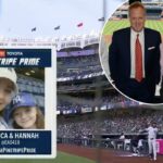 Três homens posando para uma foto em uma cabine de transmissão com vista para o Yankee Stadium.