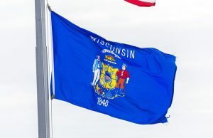 Wisconsin processa plataformas de mercado de previsões por supostas operações ilegais de apostas esportivas Bandeira do estado de Wisconsin hasteada em um mastro.