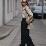 PARIS, FRANÇA - 28 DE ABRIL: Diane Batoukina usa óculos escuros grandes quadrados marrom escuro da Dior, um vestido longo branco com decote quadrado / cinto de linho, um pulôver branco de lã com nervuras branco com nó brilhante no ombro, uma bolsa de couro marrom camelo com estampa de crocodilo da Ralph Lauren, salto bloco de camurça marrom / botins pontiagudos, durante uma sessão de fotos de moda de estilo de rua, em 28 de abril de 2023 em Paris, França. (Foto de Edward Berthelot/Getty Images)