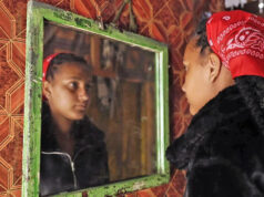 ‘Eles me disseram que ele estava morto’: crianças nascidas perto da base militar aprendem a verdade sobre pais soldados do Reino Unido Três pessoas, dois homens brancos e uma garota mestiça se reúnem em torno de uma mesa com plantas verdes e arbustos ao fundo