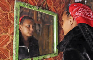 ‘Eles me disseram que ele estava morto’: crianças nascidas perto da base militar aprendem a verdade sobre pais soldados do Reino Unido Três pessoas, dois homens brancos e uma garota mestiça se reúnem em torno de uma mesa com plantas verdes e arbustos ao fundo