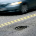 CAPE ELIZABETH, ME - FEBRUARY 22: A car drives past a pothole on Forest Ave. in Portland Tuesday, February 22, 2022. (Shawn Patrick Ouellette/Portland Press Herald via Getty Images)