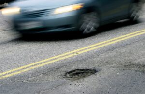 A IA está transformando carros conectados em máquinas de localização de buracos CAPE ELIZABETH, ME - FEBRUARY 22: A car drives past a pothole on Forest Ave. in Portland Tuesday, February 22, 2022. (Shawn Patrick Ouellette/Portland Press Herald via Getty Images)