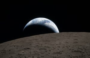 A NASA diz que colocará humanos na superfície da Lua em 2028. Quão realista é isso? Um foguete alto pousa em uma plataforma de lançamento em um dia nublado, cercado por areia, um pouco de grama verde e água.
