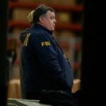 O diretor de Inteligência Nacional, Tulsi Gabbard, à esquerda, e o vice-diretor do FBI, Andrew Bailey, entram em um veículo de comando enquanto o FBI realiza as votações eleitorais do condado de Fulton em 2020, em 28 de janeiro de 2026, em Union City, Geórgia. -Mike Stewart/AP