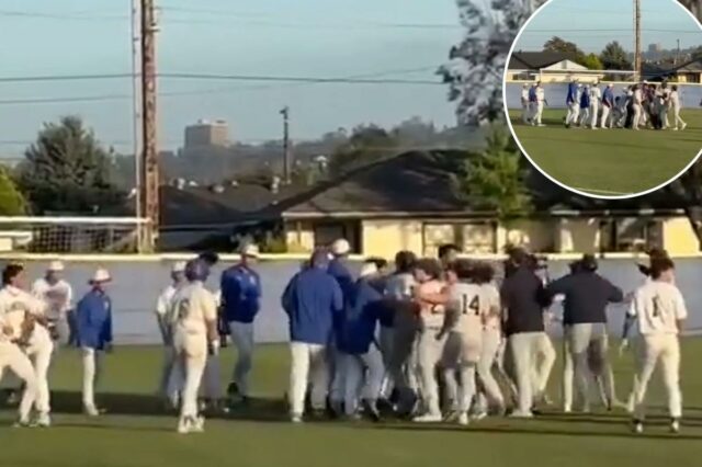 Jogadores e treinadores de beisebol brigam em campo.
