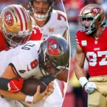 Um jogador do 49ers com uniforme vermelho e dourado enfrenta um jogador do Buccaneers com uniforme branco que está segurando uma bola de futebol.