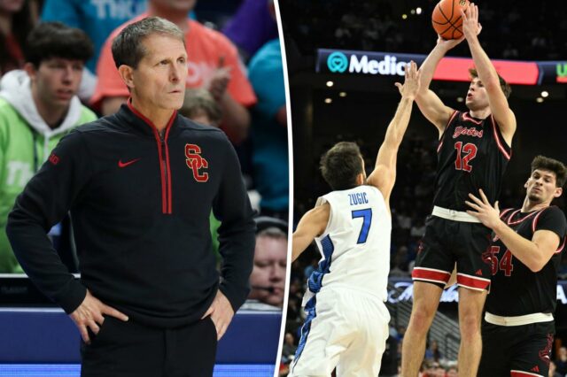 Um jogador de basquete com uniforme preto e vermelho atirando um arremesso sobre um jogador adversário.