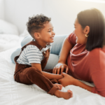 Stock image: a loving mother teaches her son to talk in a bedroom at home.