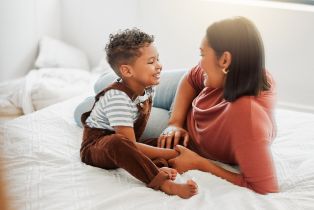 Stock image: a loving mother teaches her son to talk in a bedroom at home.
