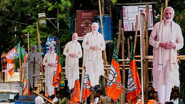 O primeiro-ministro Narendra Modi (centro) acena para os apoiadores que comemoram a vitória do BJP nas eleições para a assembleia estadual recentemente realizadas.