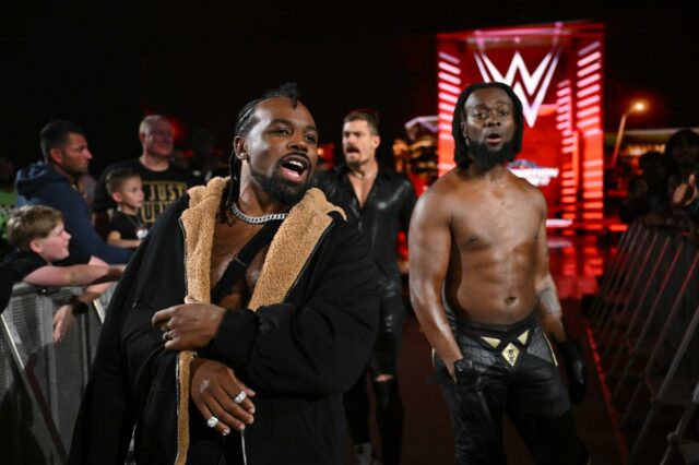 Xavier Woods e Kofi Kingston (New Day) com Grayson Waller no ringue durante Monday Night RAW 