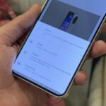 Uma mão segurando um telefone Android com o Snapseed exibido na tela