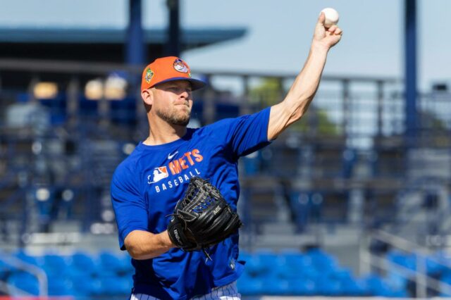 Um jogador de beisebol com uma camisa azul do Mets e um chapéu laranja jogando uma bola de beisebol durante o treinamento de primavera.