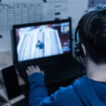 Adolescente jogando videogame online estilo Roblox em um laptop usando fone de ouvido em meio a preocupações com processos judiciais sobre jogos viciantes e microtransações
