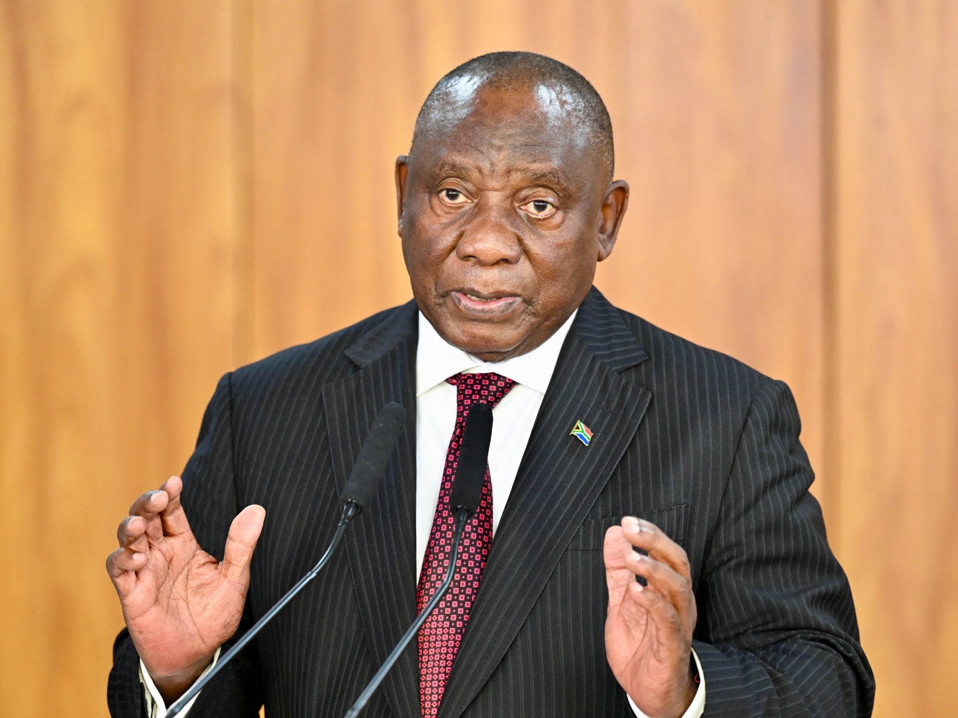 O presidente sul-africano Cyril Ramaphosa (CL) e o ex-ministro e negociador constitucional Roelf Meyer (CR) olham para os participantes durante a primeira Convenção Nacional na Universidade da África do Sul (UNISA) em Pretória, em 15 de agosto de 2025. A primeira Convenção Nacional marca o início do Diálogo Nacional (uma oportunidade onde todos os sul-africanos se reúnem para discutir os desafios do país) em reuniões locais, discussões nacionais e plataformas públicas destinadas a moldar um futuro melhor para os próximos trinta anos. (Foto de Phill Magakoe/AFP)