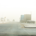 Commercial Trucks make their way through a sandstorm along Highway 285 in Texas.