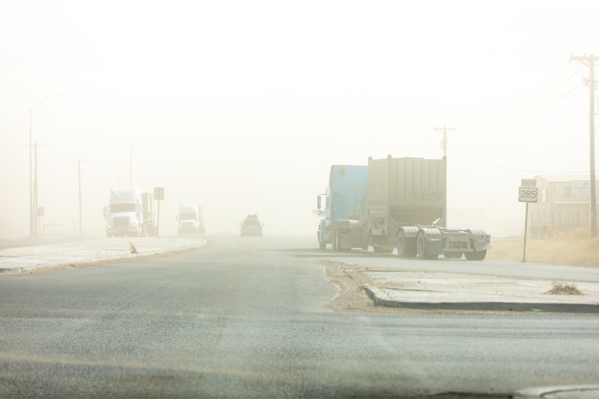 Commercial Trucks make their way through a sandstorm along Highway 285 in Texas.