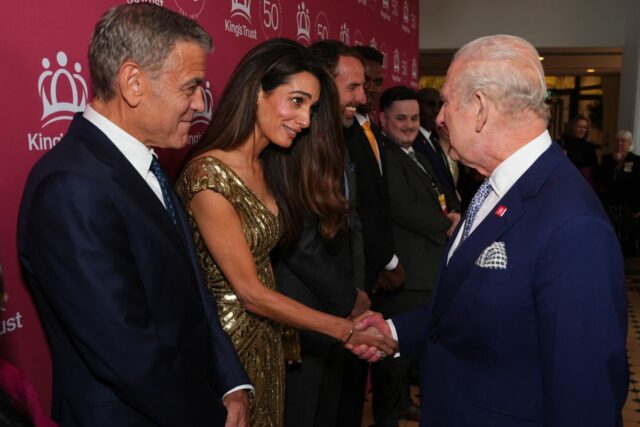Amal Clooney shakes King Charles III's hand alongside husband George Clooney at 'A King's Trust 50th Anniversary Celebration' at the Royal Albert Hall, in London, England, on May 11, 2026.