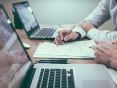 As reformas do jogo no Reino Unido podem prejudicar menos a economia do que sugerem os alertas da indústria, conclui estudo Duas pessoas estudando papelada em uma mesa com laptops.
