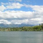 Uma imagem de Polson, Montana, com um lago em primeiro plano e montanhas ao fundo.