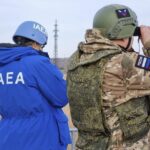 A Russian serviceman and a delegation members of the International Atomic Energy Agency (IAEA) cross the line of contact near the Karachekrak River on the territory of Zaporizhzhia region of Ukraine on February 7, 2024. This image was provided to AP by a third party and could not be independently verified.