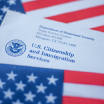 Washington, DC, USA - September, 16, 2019: Letter from USCIS covered in flag of USA on American colors background - stock photo