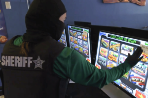 Autoridades da Flórida prendem rede de jogos ilegais do condado Investigador do xerife da Flórida examina máquinas caça-níqueis ilegais durante operação de fiscalização de fliperamas no condado de Manatee e repressão aos jogos em todo o estado da Flórida