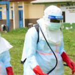 Profissionais de saúde preparam desinfecção num centro de tratamento na República Democrática do Congo.