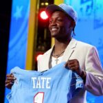Ohio State receiver Carnell Tate holds up a Titans jersey after becoming the team's fourth overall pick at NFL Draft