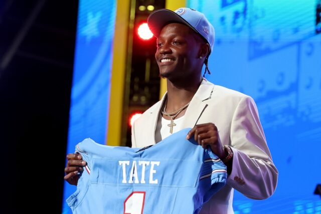 Ohio State receiver Carnell Tate holds up a Titans jersey after becoming the team's fourth overall pick at NFL Draft