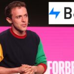 Um jovem de cabelo castanho claro e um moletom colorido fala em uma cadeira branca no Forbes Under 30 Summit.