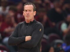 Cavaliers tomam decisão de Kenny Atkinson após serem varridos pelos Knicks Um homem com uma camisa preta de mangas compridas com um emblema dourado no ombro esquerdo, braços cruzados, olhando atentamente.