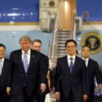 O presidente dos EUA, Donald Trump, é recebido por jovens chineses, uma guarda de honra militar e uma banda militar ao chegar ao Aeroporto Internacional de Pequim, na quarta-feira.