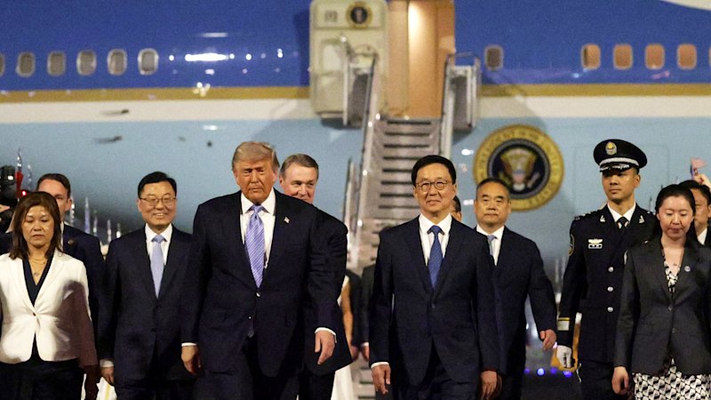 O presidente dos EUA, Donald Trump, é recebido por jovens chineses, uma guarda de honra militar e uma banda militar ao chegar ao Aeroporto Internacional de Pequim, na quarta-feira.